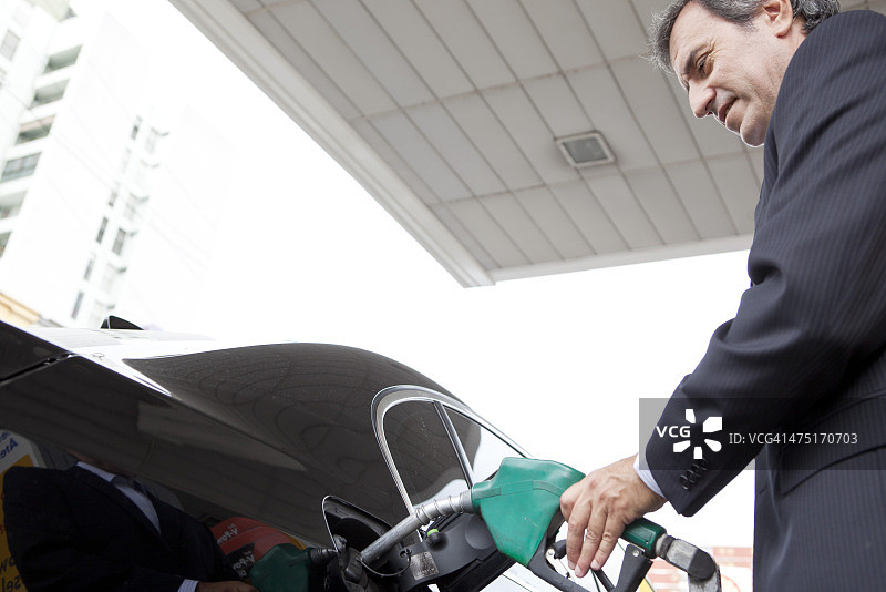 商人在加油站给汽车加油图片素材