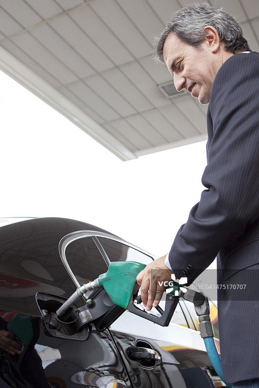 商人在加油站给汽车加油图片素材