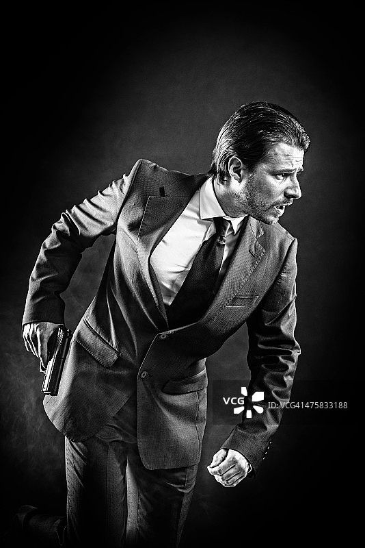 黑手党党徒，歹徒，穿西装拿枪，头发向后梳的男人图片素材
