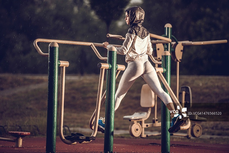 雨天在椭圆机上锻炼的女人图片素材