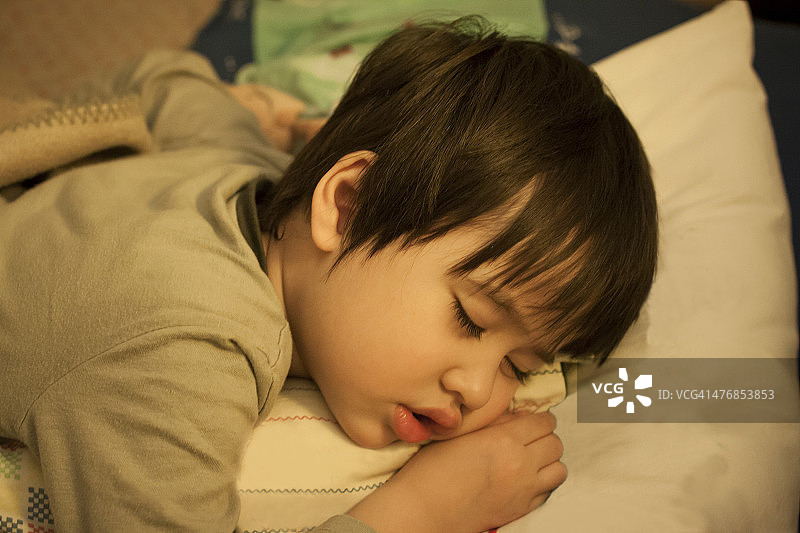小男孩在床上睡觉图片素材
