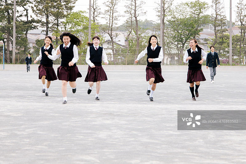 日本高中校园里奔跑的女学生图片素材
