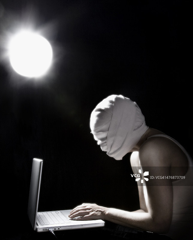 头部受伤缠着绷带，使用笔记本电脑工作的人图片素材