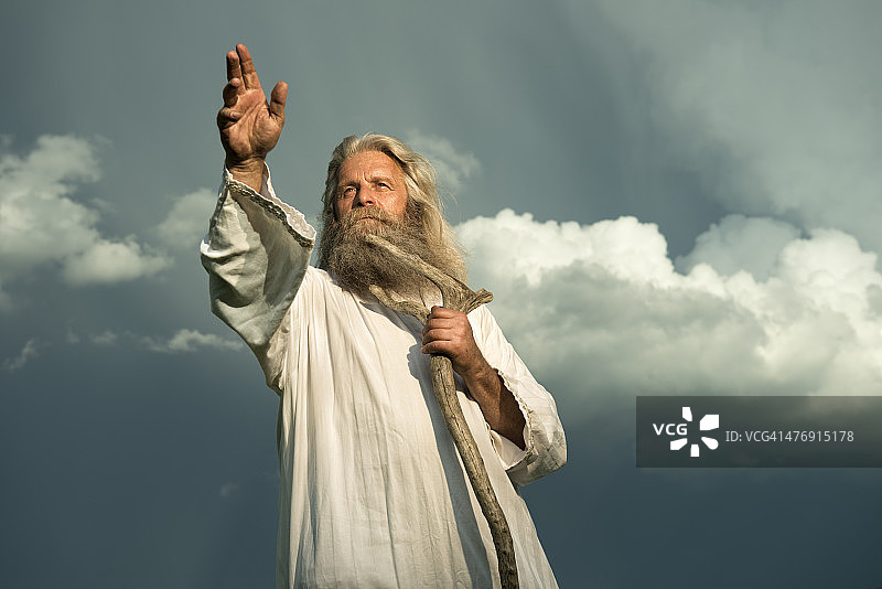 在戏剧性天空前做手势的长发预言家图片素材