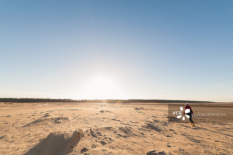 在荒凉的海滩上奔跑的幼儿图片素材