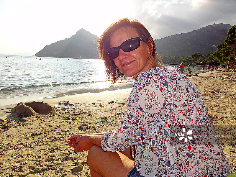 戴着太阳镜在海滩上的女人图片素材