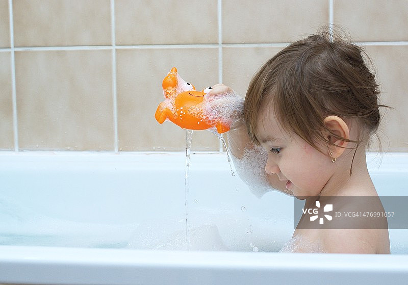 幼儿女孩在浴缸里玩耍图片素材