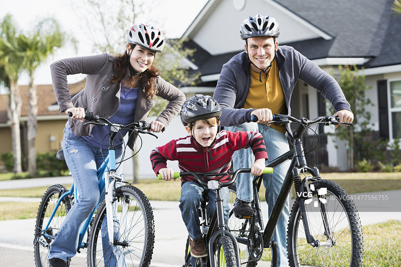 年轻家庭和骑自行车的男孩图片素材