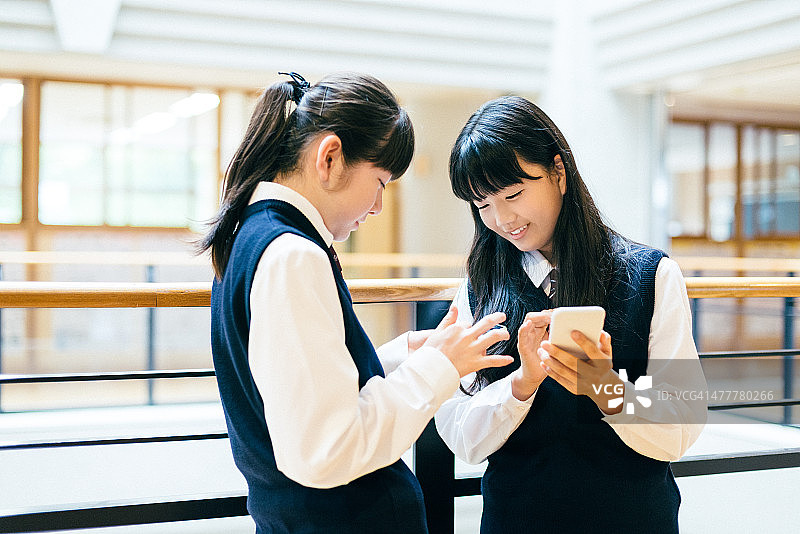 日本高中女生在学校使用智能手机图片素材