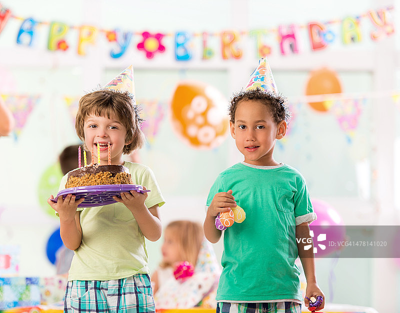 微笑看着镜头的过生日的男孩们图片素材