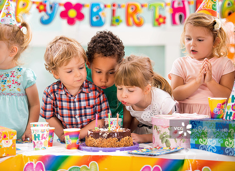 孩子们在生日聚会上吹生日蜡烛图片素材