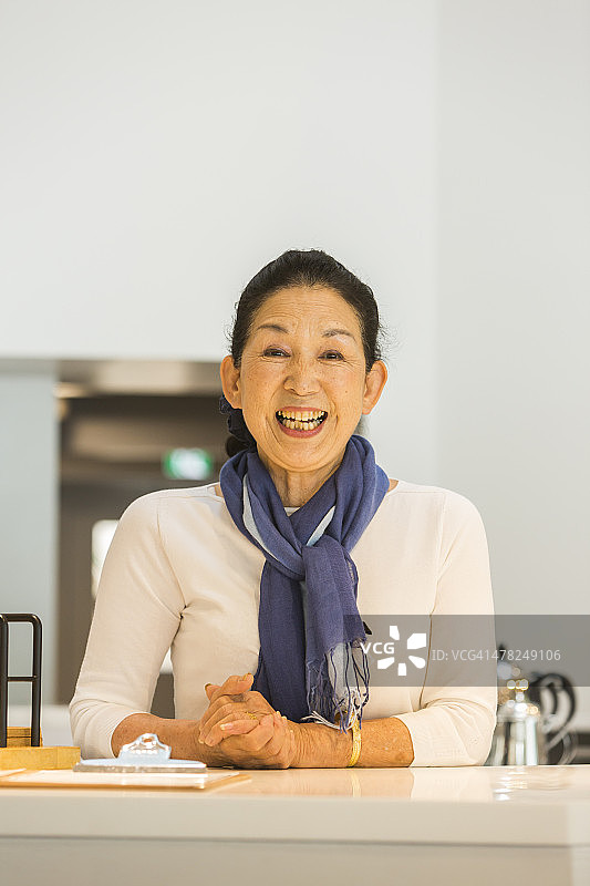 在咖啡馆迎接顾客的年长日本妇女图片素材