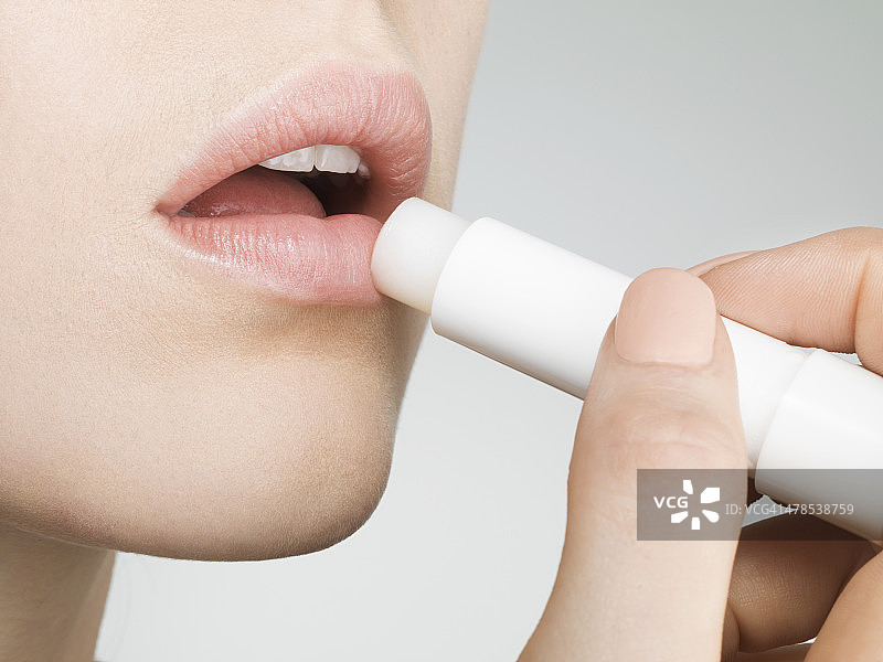 女人涂润唇膏，特写，侧视图图片素材