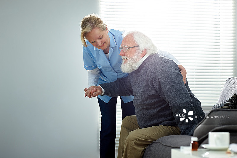 帮助老年男性的女护理员图片素材