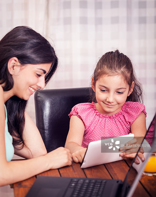 年轻家庭使用各种数码设备图片素材