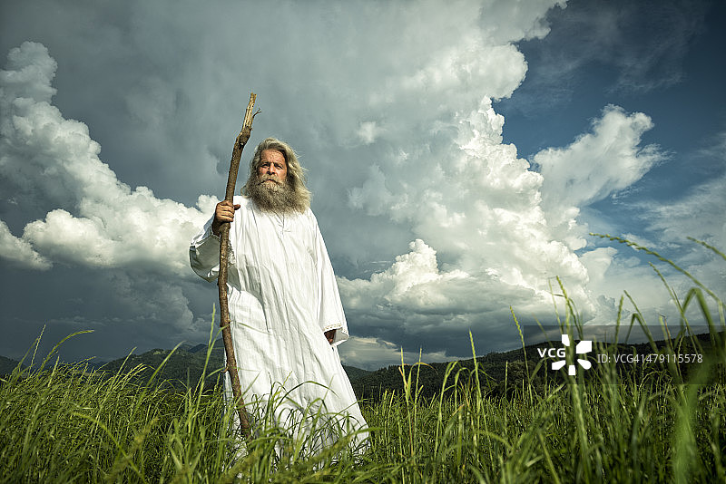 站在戏剧性天空下的长发预言家图片素材