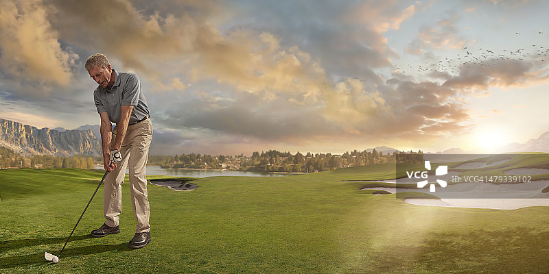 高尔夫球手准备在日落时分的球场上击球图片素材