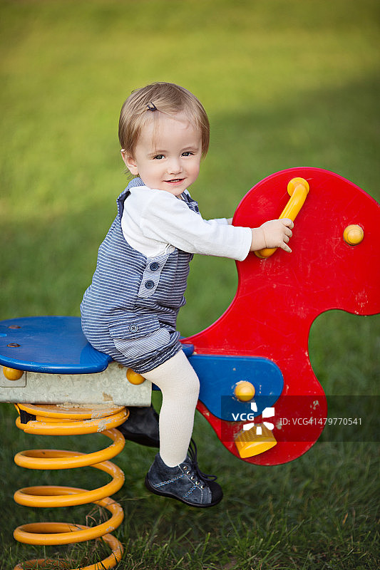 14个月大的幼儿在摇马上玩耍图片素材