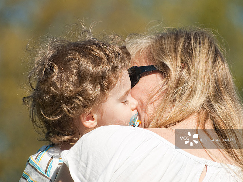 金发女子亲吻婴儿特写图片素材