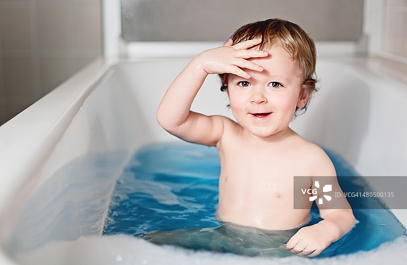 坐在浴缸里扮演船长的小男孩图片素材