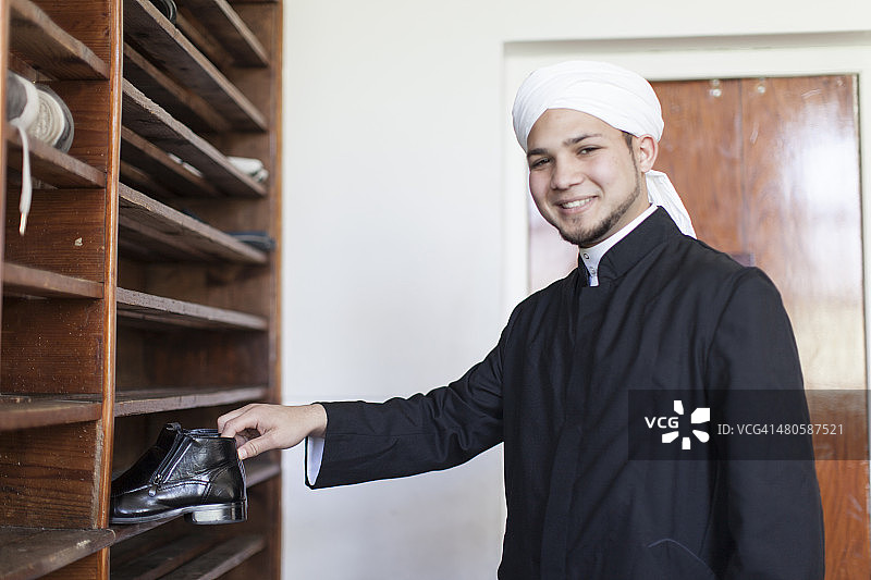 穆斯林男子将鞋子放在鞋架上（开普敦）图片素材