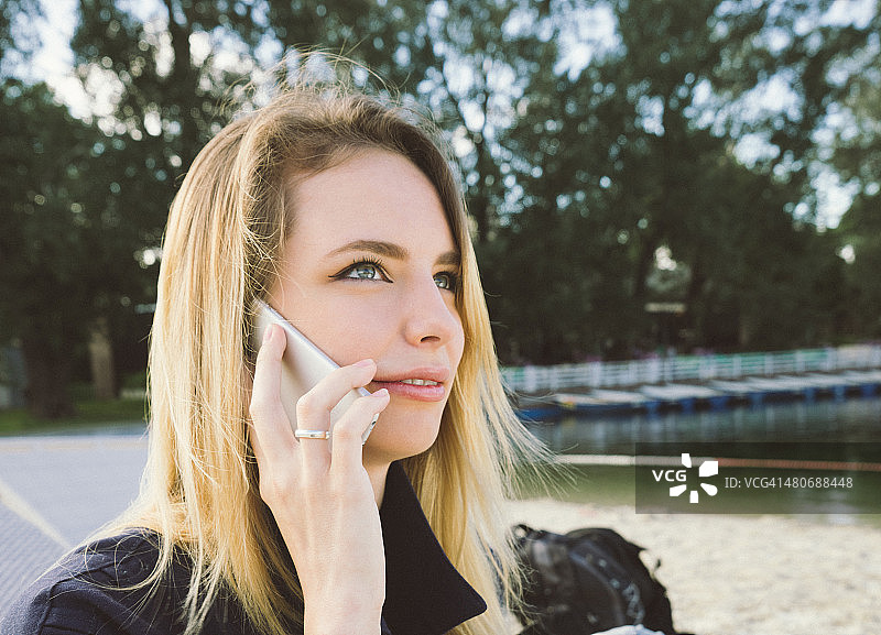在公园里打电话的年轻漂亮女人图片素材