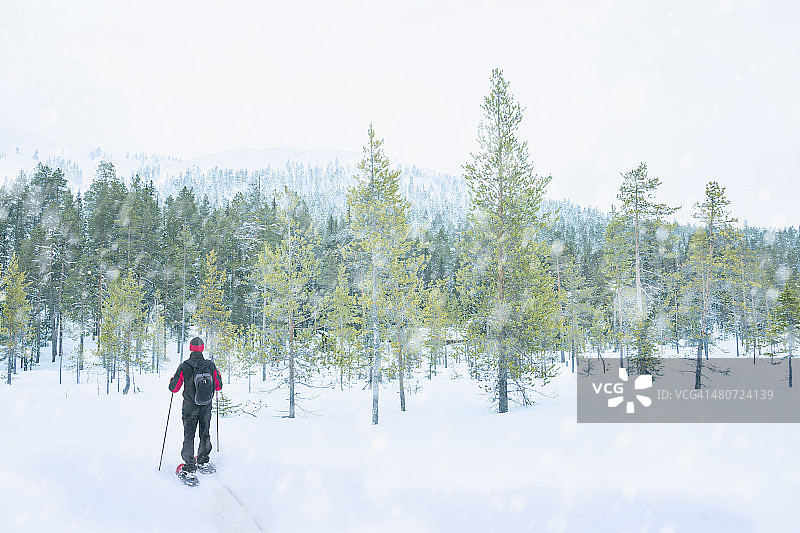 冬季穿着雪鞋的男人越过山丘图片素材