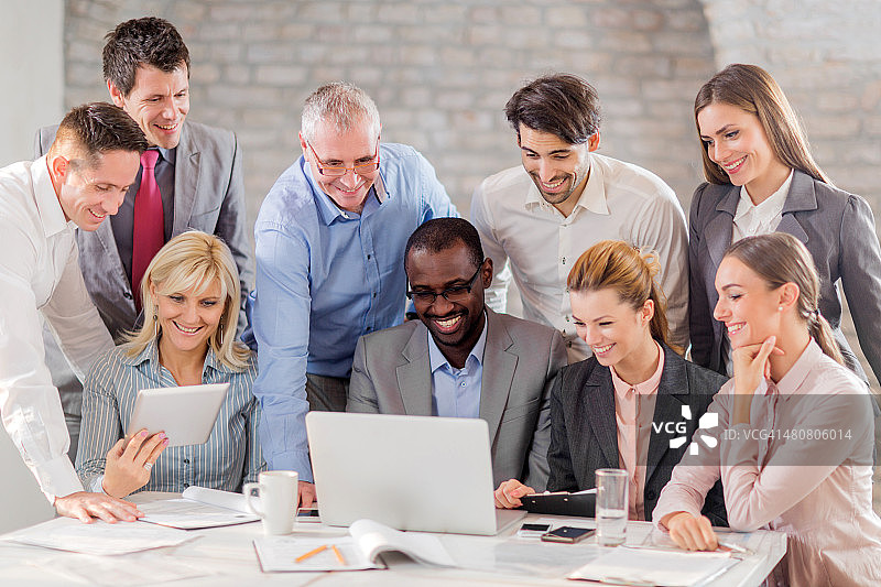 快乐的商人们在办公室使用无线技术图片素材