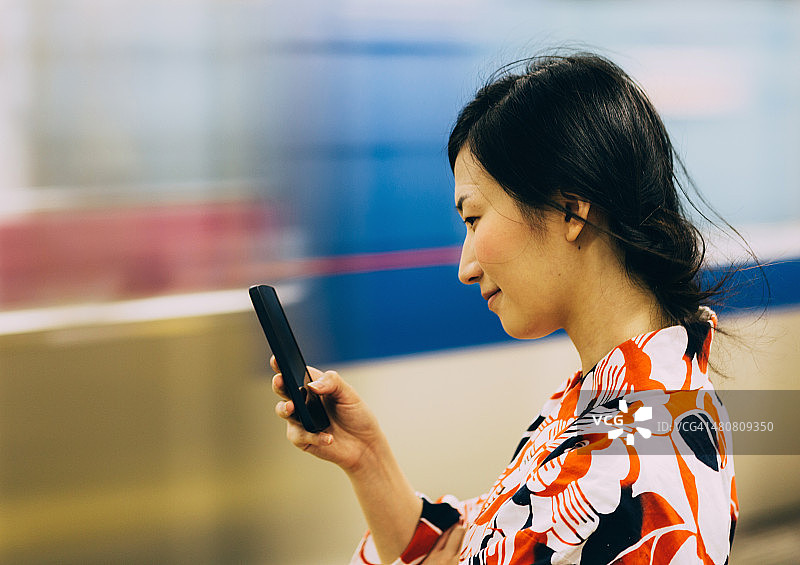 用手机发短信的漂亮日本女人图片素材