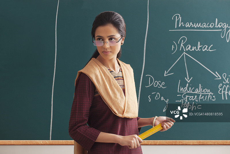 手持戒尺的生气女讲师，背景为黑板图片素材