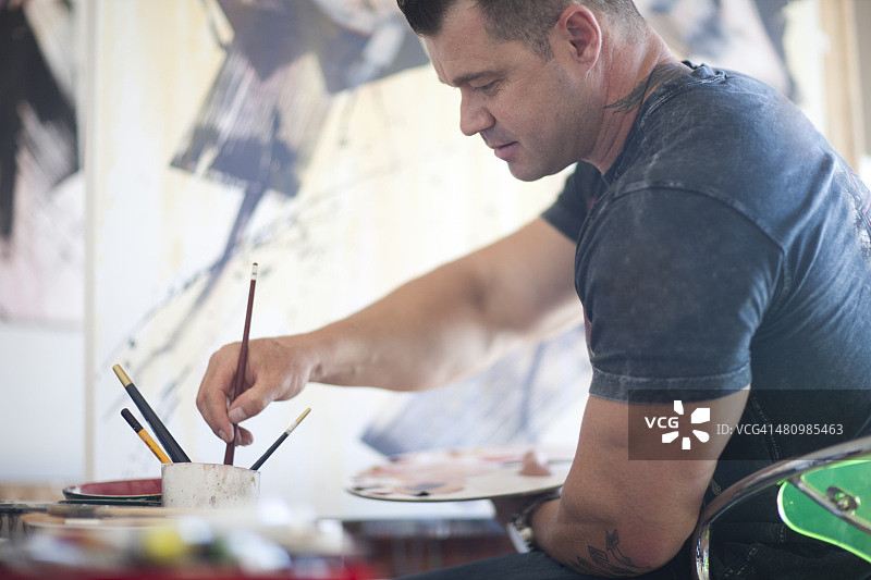在工作室里创作的年长男艺术家图片素材