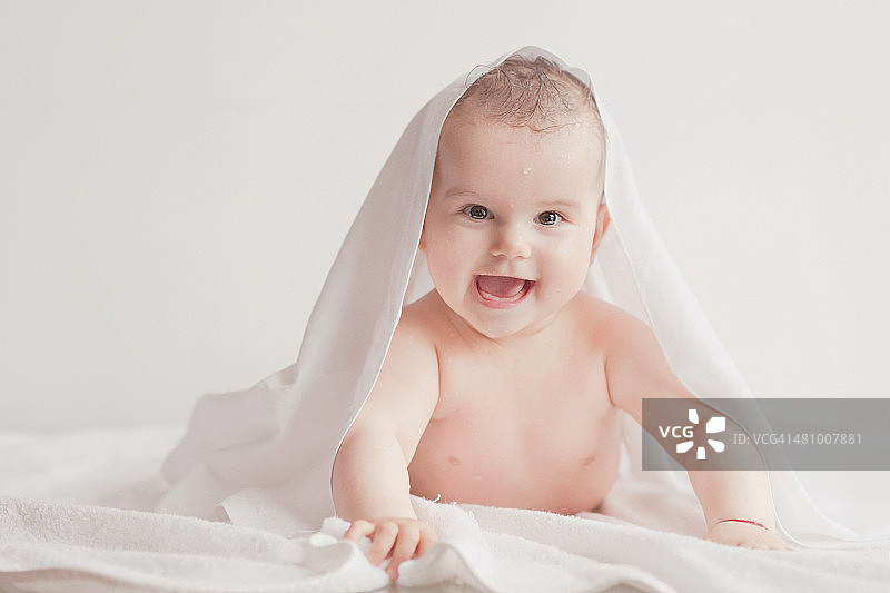 裹着浴巾微笑的婴儿图片素材