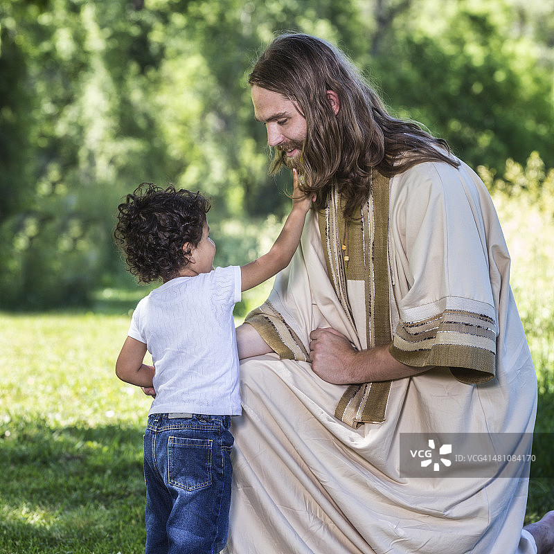 小男孩触摸跪着的耶稣的胡须图片素材