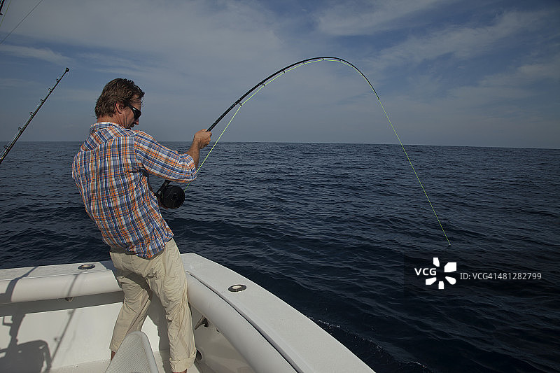 男人用飞钓竿在海里钓旗鱼图片素材