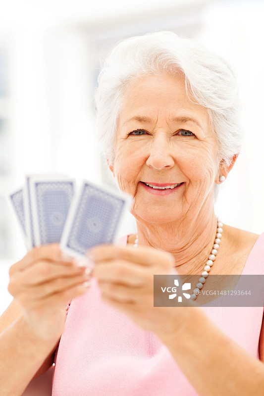 快乐的老年妇女玩纸牌图片素材