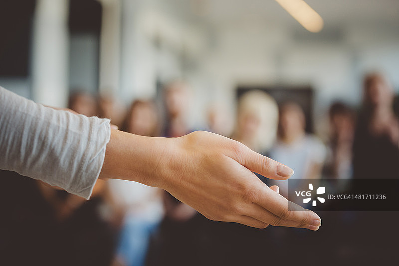 女人手与散焦的学生群体图片素材
