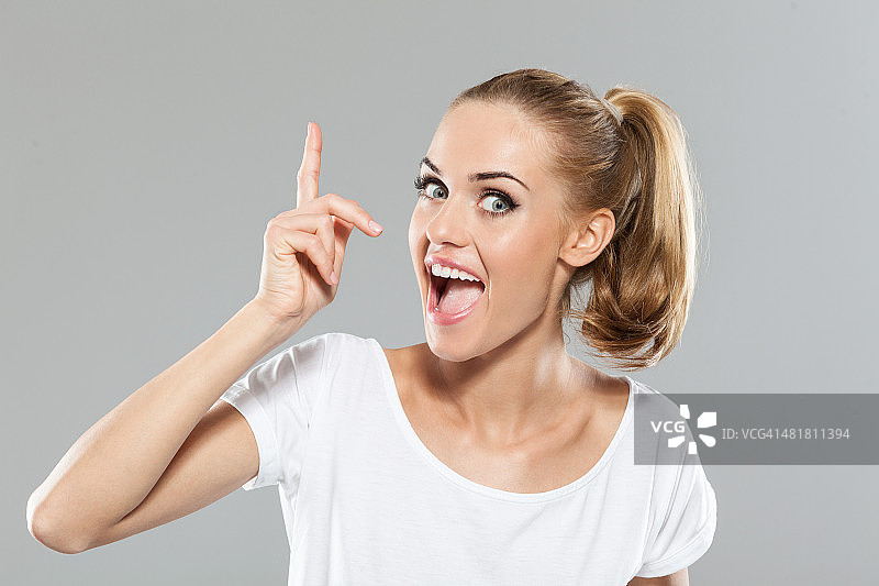 兴奋的金发年轻女人指向图片素材