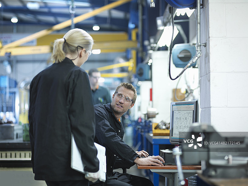 工程师在工厂使用电脑查看工程计划图片素材