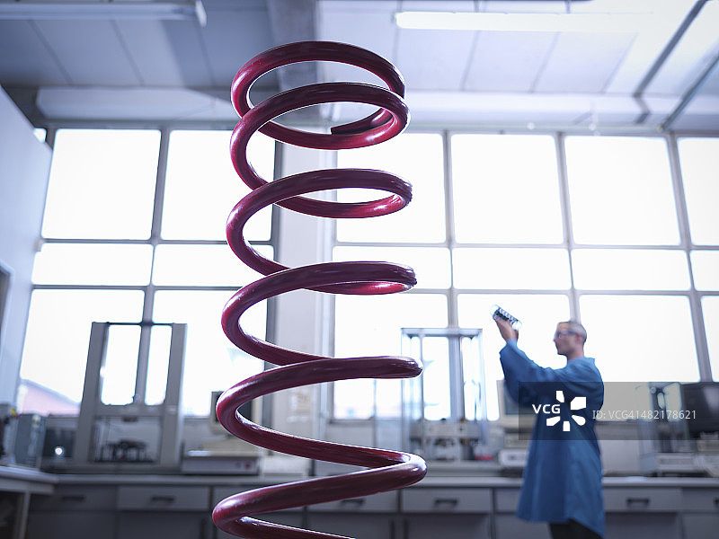 在实验室检查弹簧的工人，焦点在前景色上图片素材