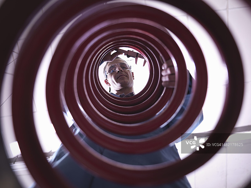 实验室工人检查弹簧，仰视图片素材