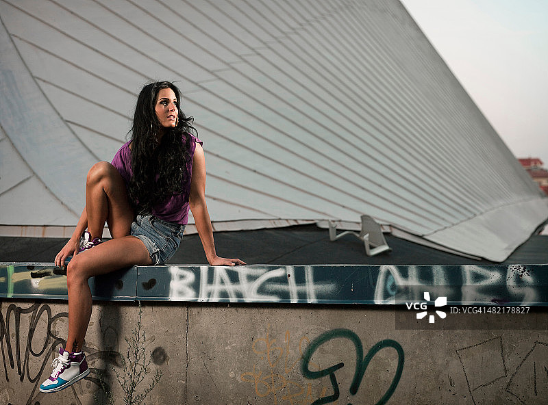 坐在涂鸦墙边的女人图片素材