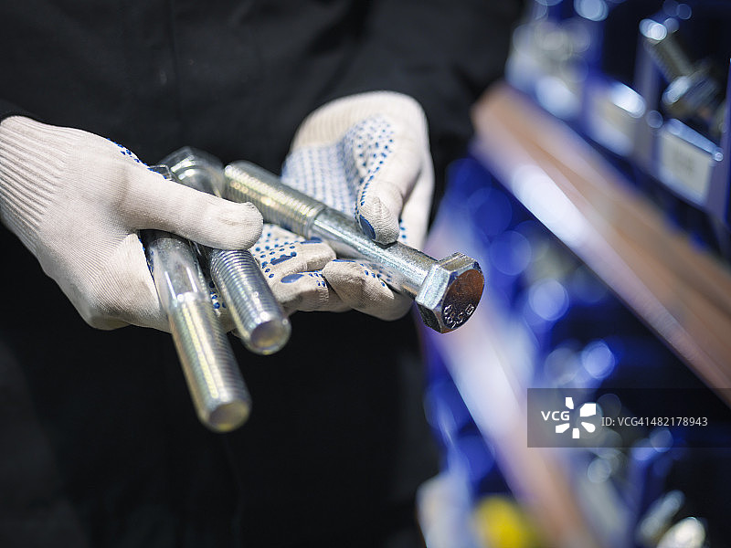 工程师在工厂挑选螺栓特写图片素材