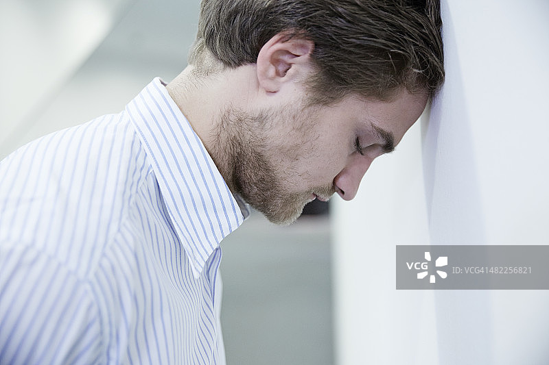 德国诺伊斯，商务男士靠墙休息图片素材