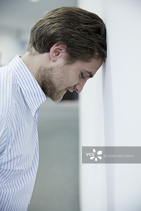 德国诺伊斯，商务男士靠墙休息图片素材