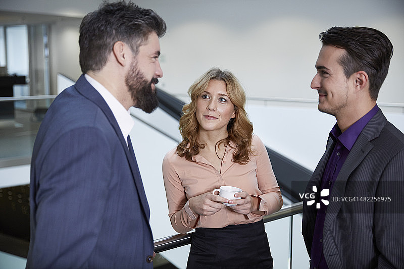 德国诺伊斯：同事在走廊里交谈图片素材