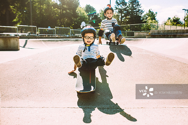 兄弟在公园玩滑板图片素材