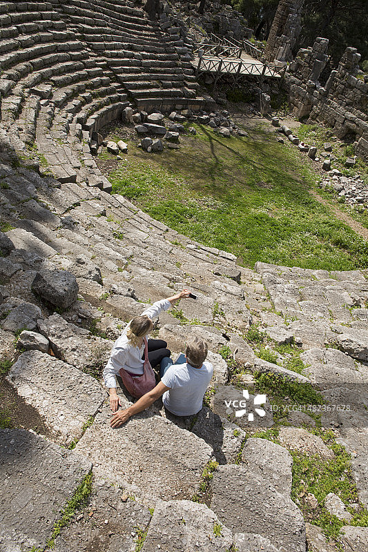 情侣坐在古希腊剧院遗址台阶上图片素材