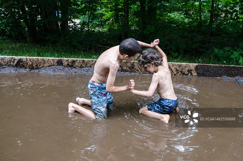 在泥地里打架的两个孩子图片素材