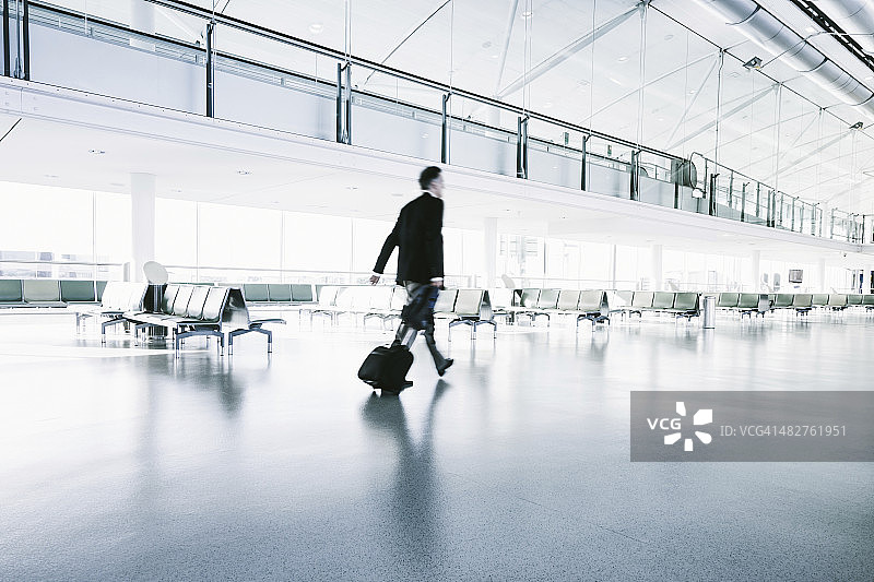 穿着西装的商人走在机场航站楼图片素材