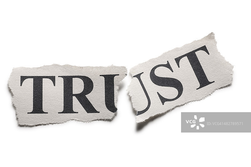 撕成两半的纸上印着“信任”字样图片素材